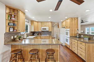 Kitchen featuring a peninsula, a kitchen breakfast bar, ceiling fan, and recessed lighting