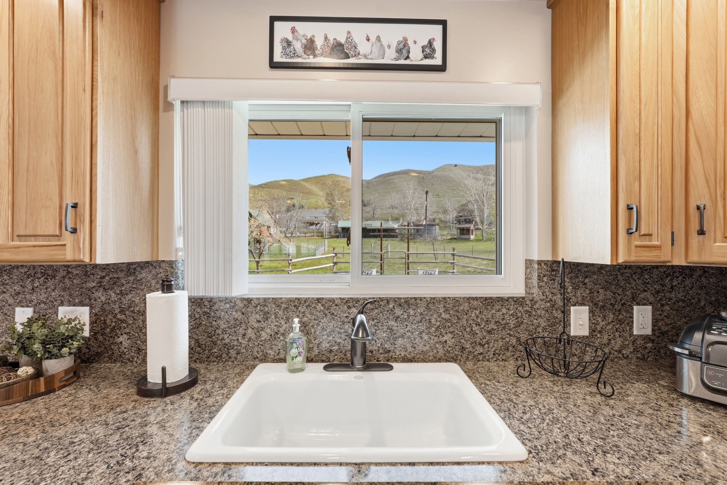 Kitchen view of light wood finish cabinetry, tasteful backsplash, and dark stone counters