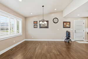 Unfurnished dining area featuring dark wood-style flooring and recessed lighting