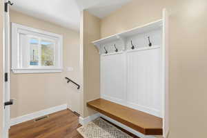 Mudroom featuring dark wood-style floors and baseboards