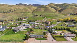 Aerial view of property and surrounding area with nearby area and a mountainous background