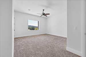 Empty room featuring light colored carpet and a ceiling fan