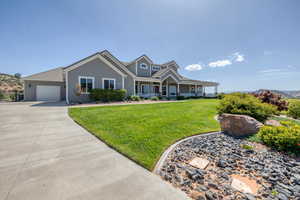 View of front of property featuring covered porch, a front yard, a garage, driveway, and a mountain view