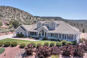 View of front of property featuring a porch, a mountain view, a tile roof, and a front yard