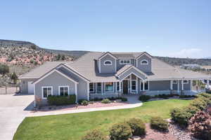 View of front facade featuring a porch, a tiled roof, a front lawn, and concrete driveway