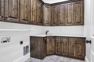 Laundry room featuring washer hookup, electric dryer hookup, and cabinet space