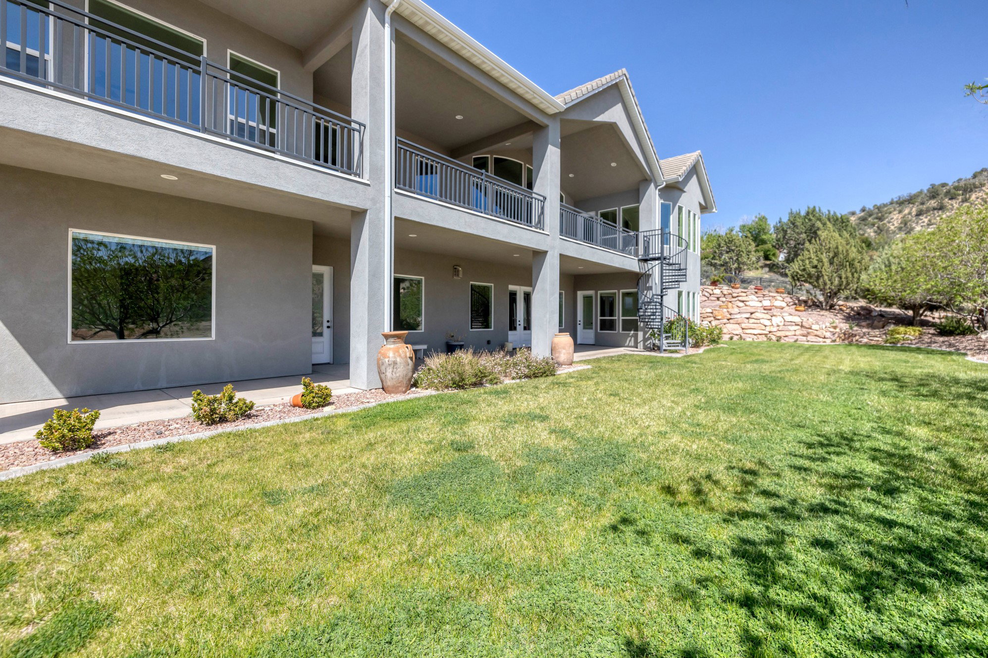 Back of house featuring stucco siding, a patio, and a yard