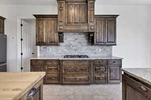 Kitchen with dark wood finish cabinetry and backsplash