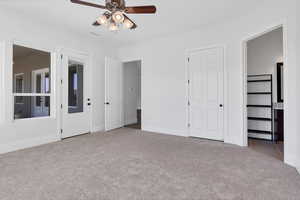 Unfurnished bedroom featuring connected bathroom, carpet, and ceiling fan