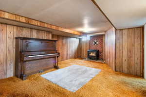 Living area with light colored carpet and wood walls