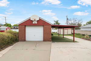 Garage with a storage unit, concrete driveway, and a detached garage