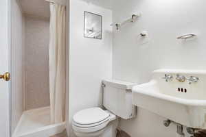 Bathroom featuring a stall shower and toilet