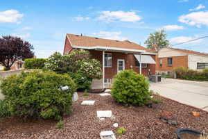 View of front of home featuring a shingled roof and brick siding
