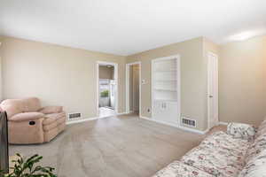 Sitting room with built in features and light colored carpet