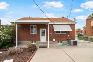 Back of property featuring roof with shingles, a patio, and brick siding