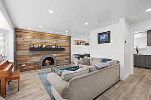 Inviting living room with updated flooring, recessed lighting, and a statement fireplace with wood accent wall for added warmth and character.