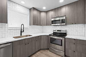 Thoughtfully updated kitchen with stylish cabinetry, crisp tile backsplash, stainless steel appliances, and a statement sink that ties the space together.