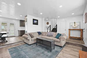 Open living space with updated flooring, recessed lighting, and seamless flow to dining and kitchen areas.