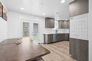 Updated kitchen with modern cabinetry, tile backsplash, and stainless steel appliances, opening to dining area with backyard access.