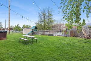 Fenced backyard with a storage unit and a playground