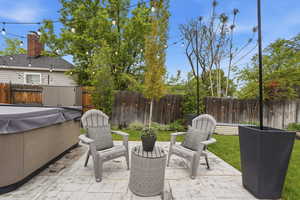 Fenced backyard with a patio, a shed, and a hot tub