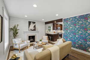 Living room featuring recessed lighting, wood finished floors, a fireplace with flush hearth, and wood walls