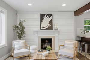 Sitting room featuring wood finished floors, a fireplace with flush hearth, and recessed lighting