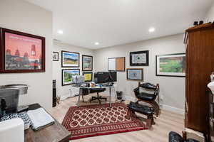 Office area with light wood-type flooring and recessed lighting