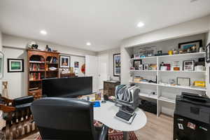 Home office with light wood-style flooring and recessed lighting