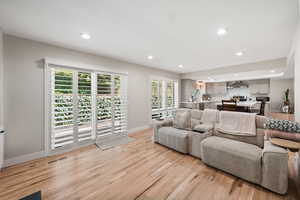 Living area featuring light wood-style floors and recessed lighting