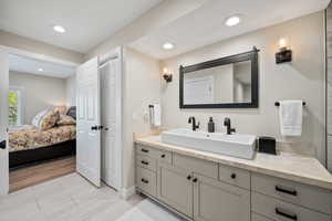 Ensuite bathroom with vanity, wood finish floors, and recessed lighting