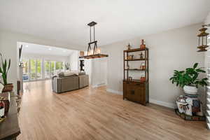 Dining space featuring light wood finished floors, a chandelier, and lofted ceiling