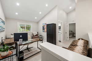 Office space featuring light colored carpet, lofted ceiling, and recessed lighting