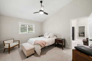Bedroom with vaulted ceiling, light colored carpet, and ceiling fan