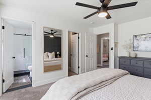 Bedroom with connected bathroom, carpet floors, and a ceiling fan
