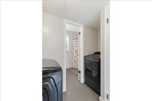 Laundry room with washing machine and dryer and a textured ceiling