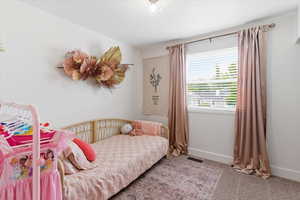 Bedroom with baseboards and light carpet