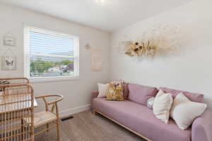 Living area featuring carpet floors and baseboards