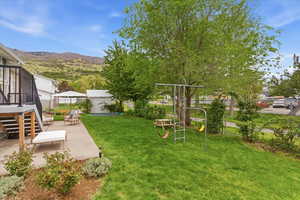 View of yard featuring a patio area, a playground, and a mountain view