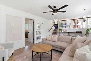 Living room featuring wood finished floors, healthy amount of natural light, and ceiling fan