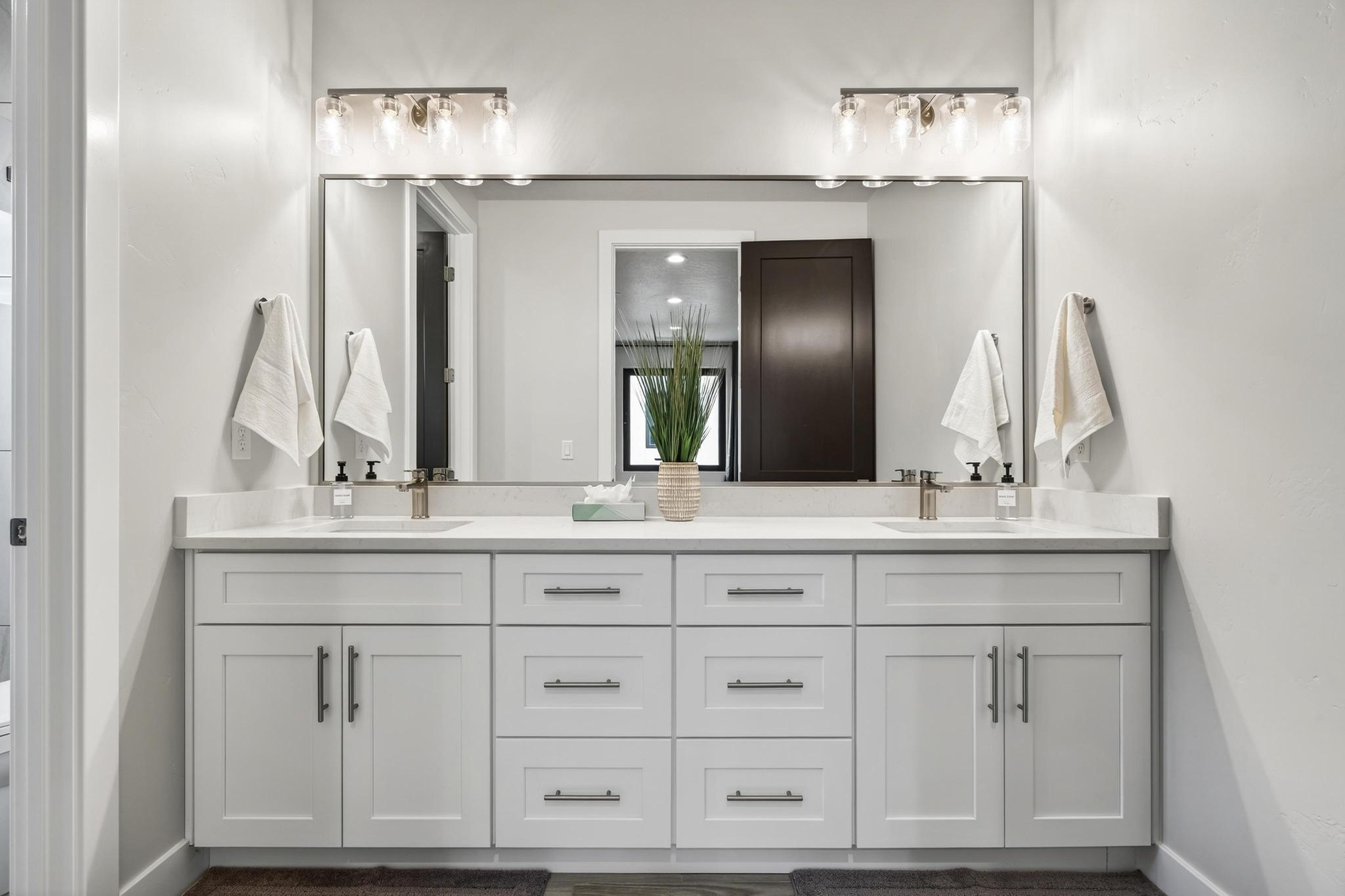Full bath with double vanity and baseboards