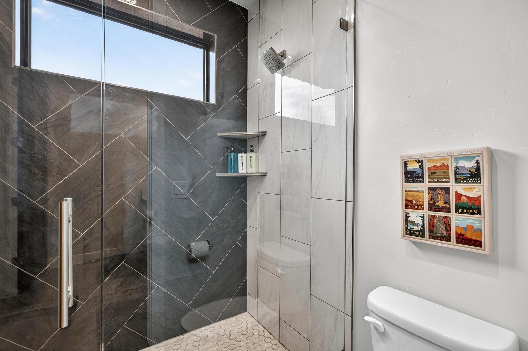 Full bath featuring a shower stall and toilet