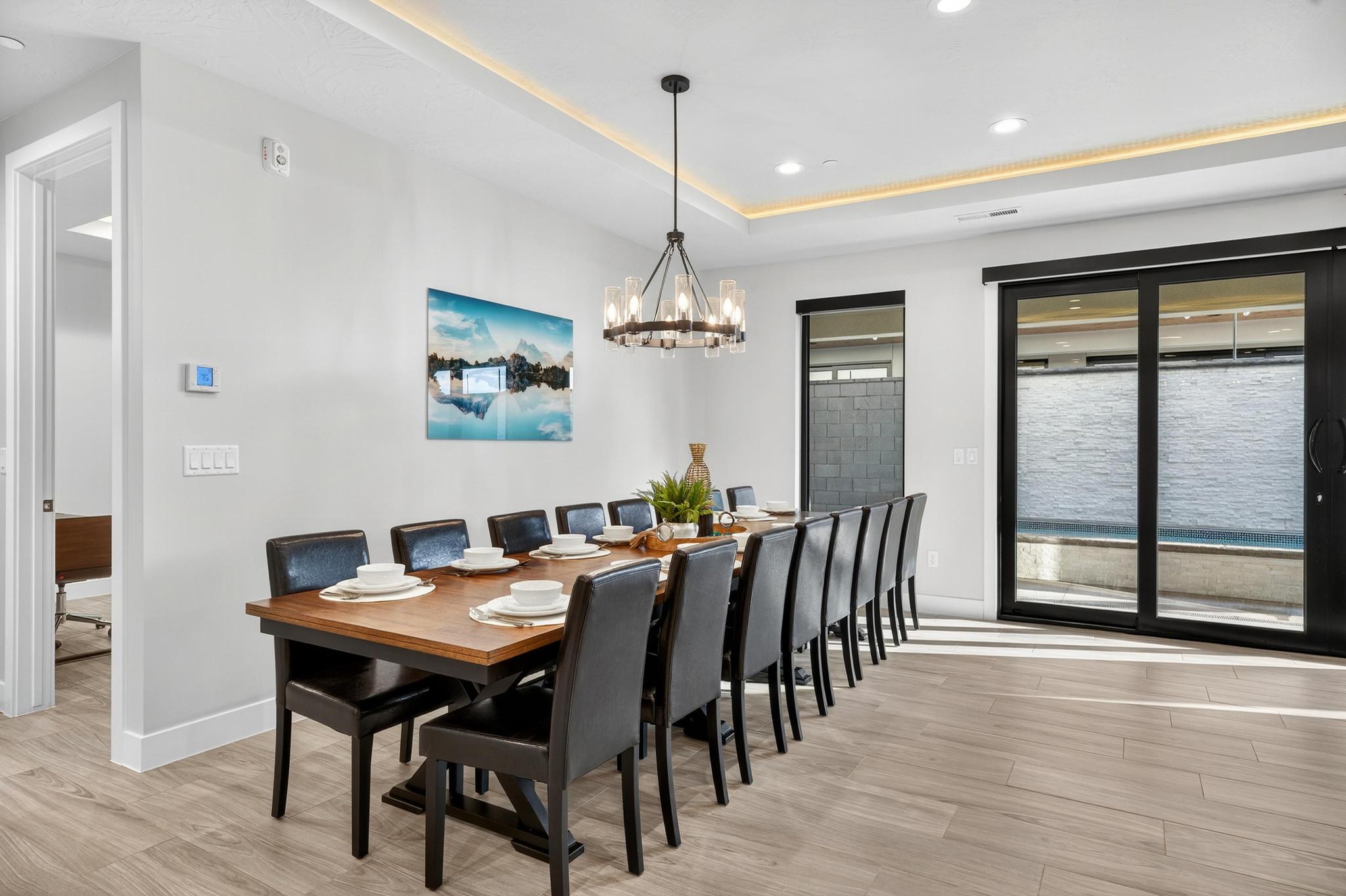 Dining room with light wood finished floors, a tray ceiling, and a chandelier