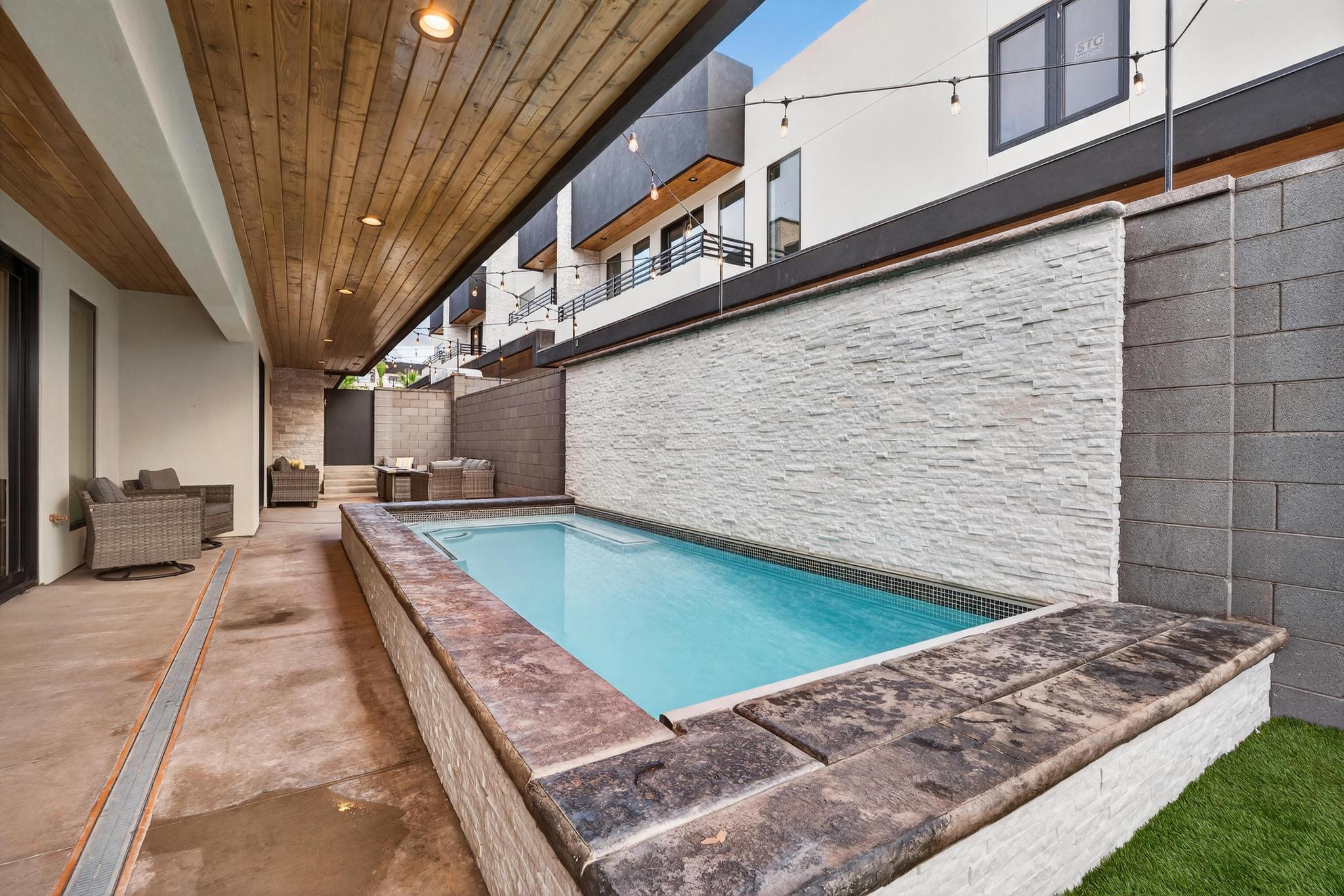 View of pool featuring an outdoor living space, a fenced backyard, and patio surround