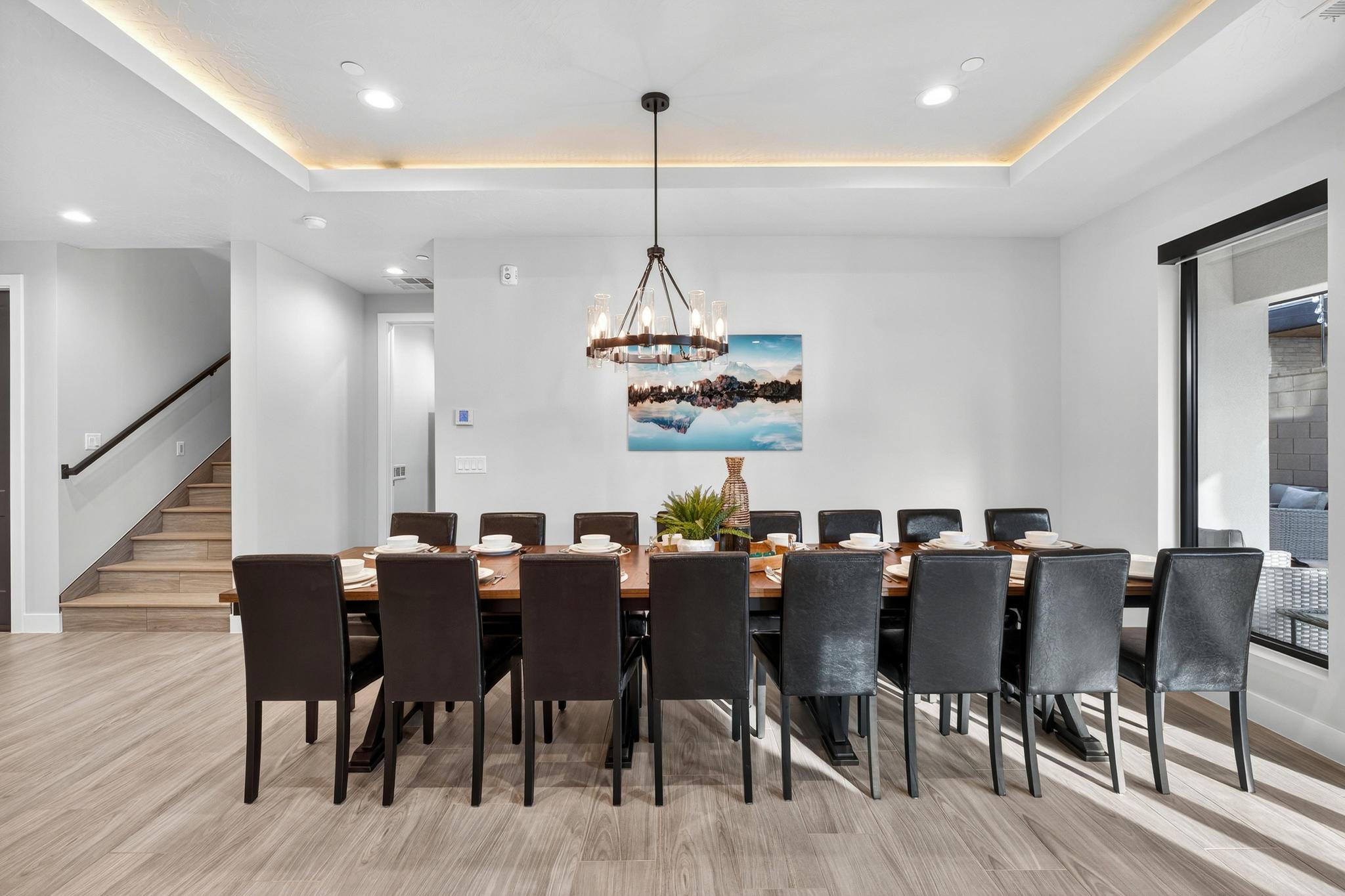 Dining area with a raised ceiling, a chandelier, and light wood-style floors