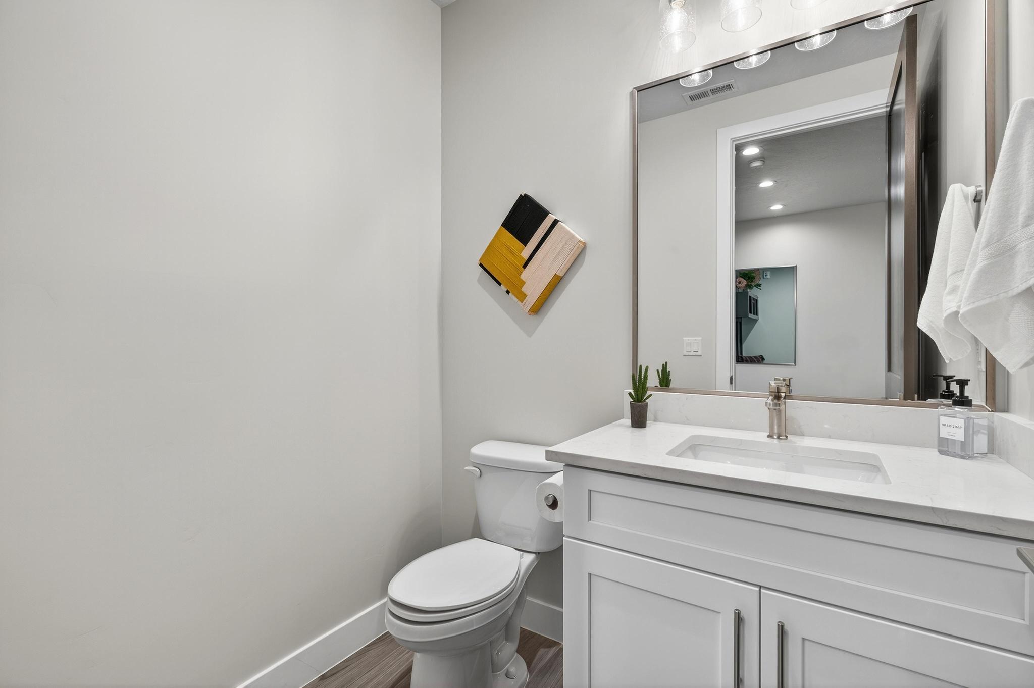 Half bath with vanity, dark wood-type flooring, and recessed lighting