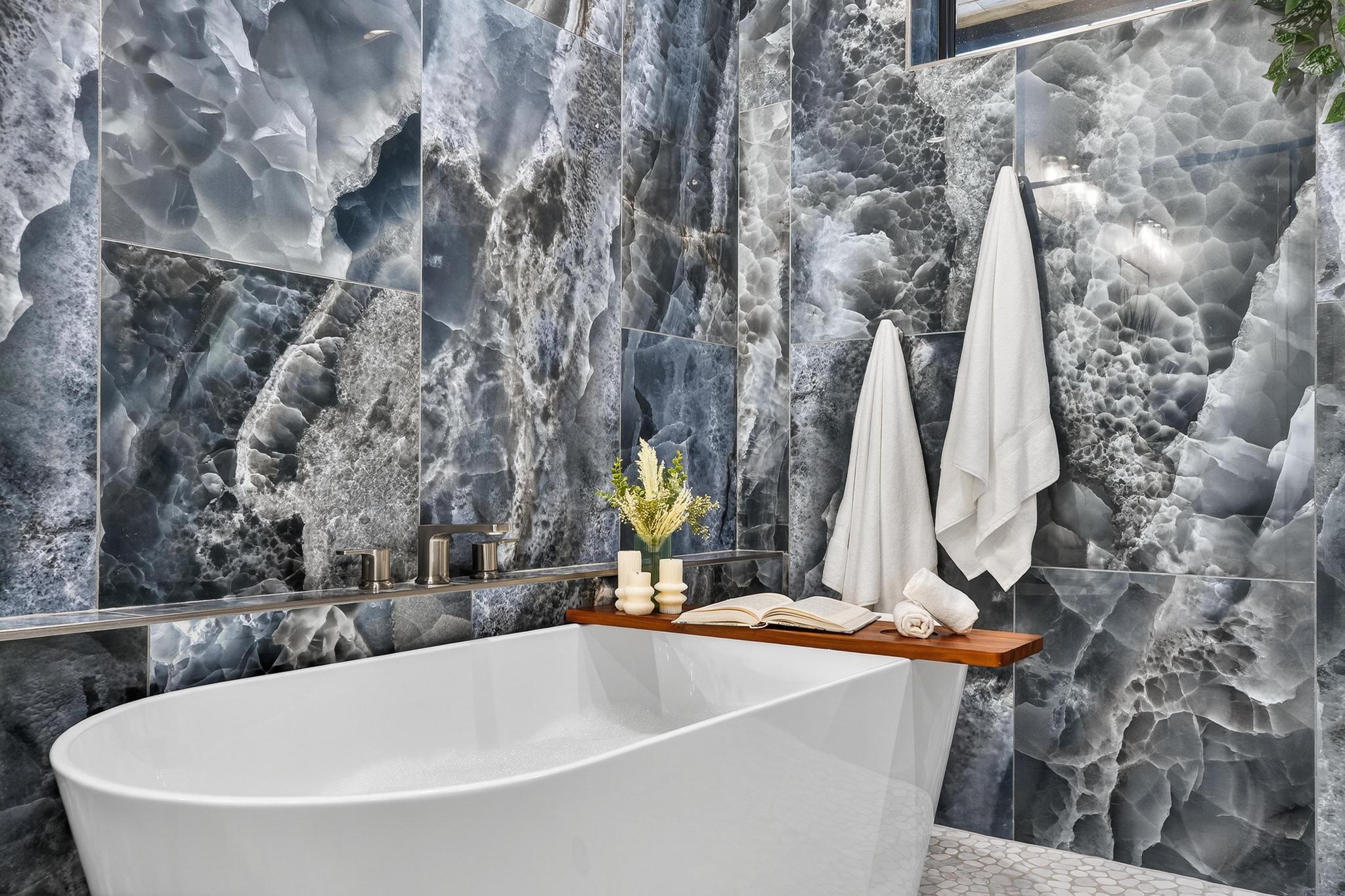 Full bathroom featuring a soaking tub and tile walls