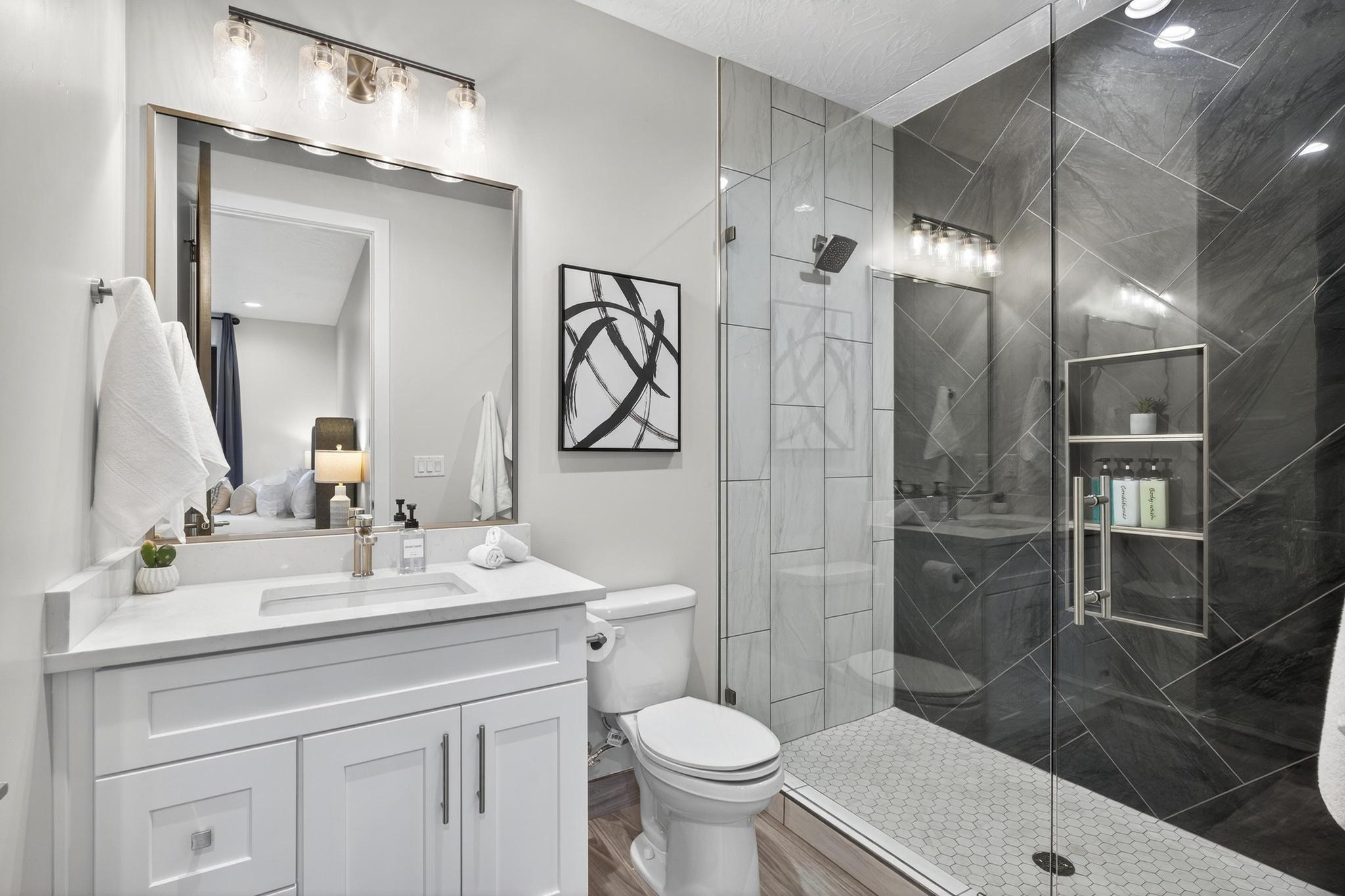 Ensuite bathroom featuring vanity and a marble finish shower