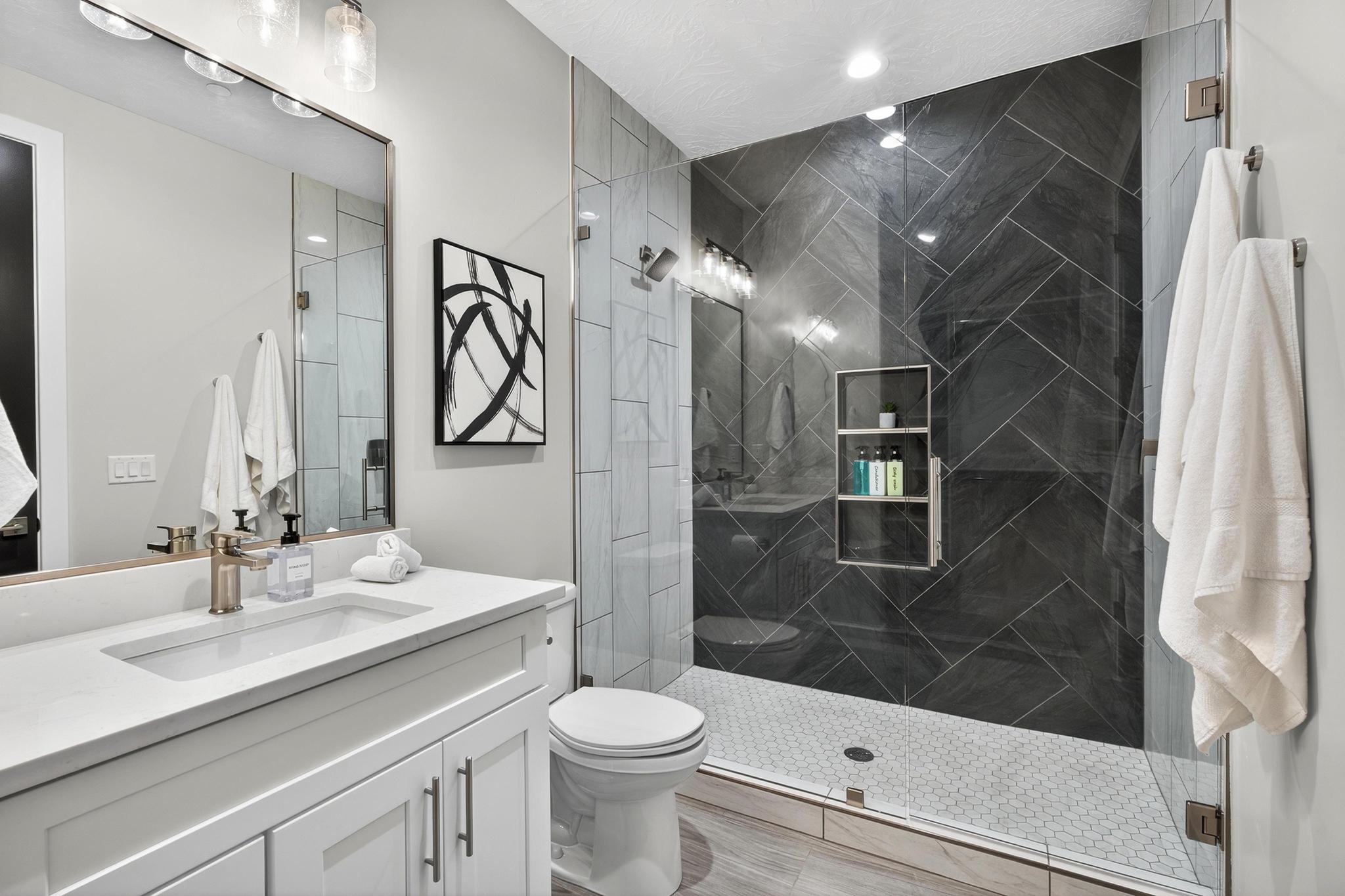 Full bathroom featuring vanity, a marble finish shower, and recessed lighting