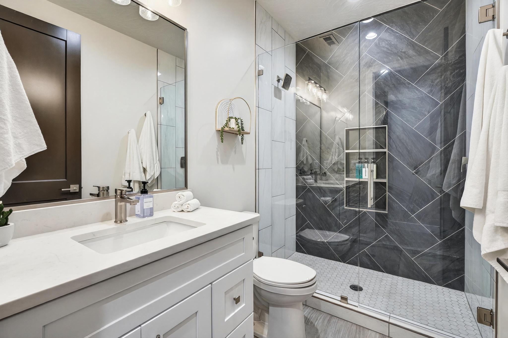 Bathroom with vanity and a marble finish shower